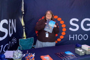 A person in a stall holding a leaflet